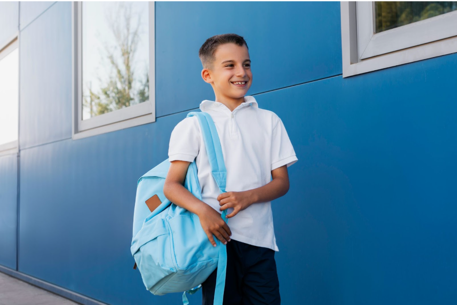 усмихнато момче със синя раница на гърба