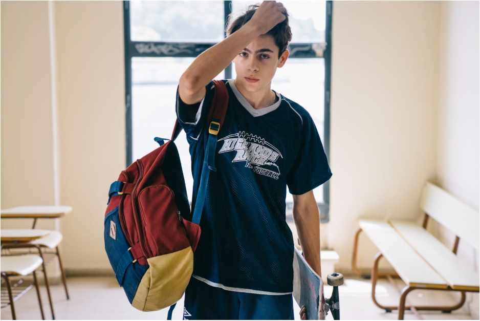 момче със скейтборд в ръка и раница на гърба