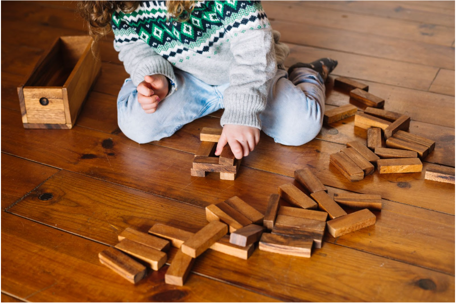 дете играе с дървен пъзел