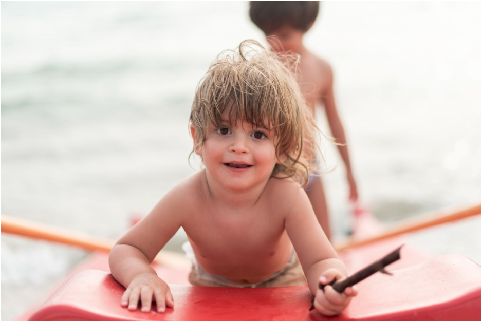 Дете кара надуваем SUP борд и се радва